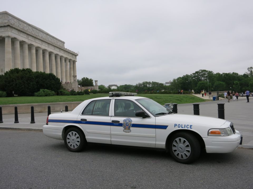 White Crown Victoria police car with blue stripe at Lincoln Memorial