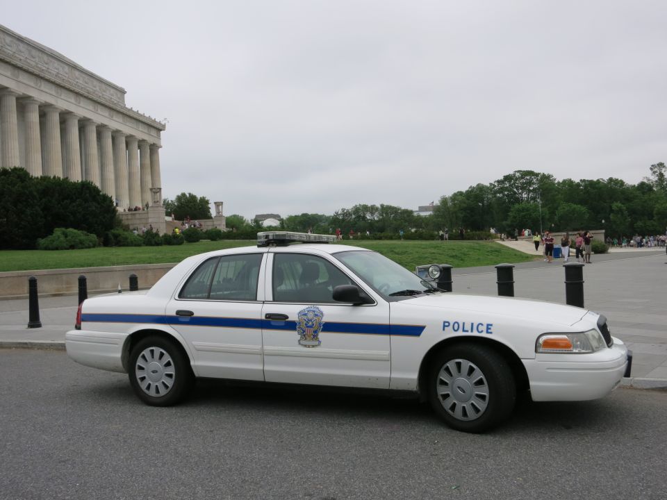 White Crown Victoria police car side view at Lincoln Memorial