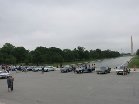 1991 Ford LTD Crown Victoria - wide view of many vintage cars parked along the Mall plaza beside the reflecting pool, with crowds and the Washington Monument in the dista…
