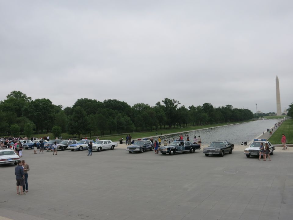 Wide view of vintage cars parked along reflecting pool, Washington Monument