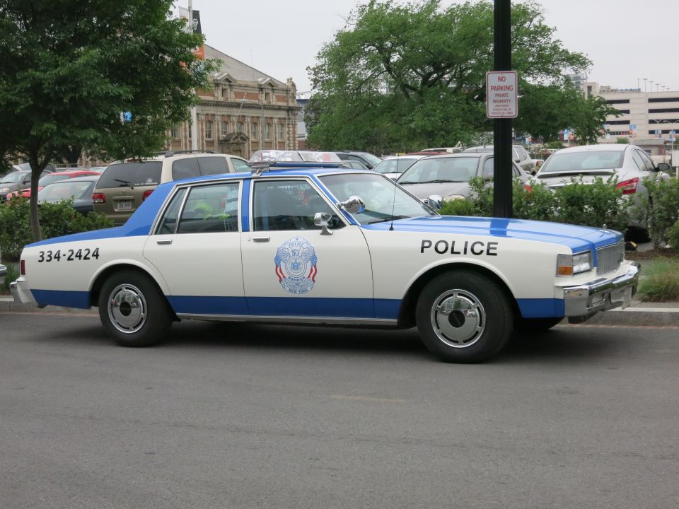 White and blue Chevrolet Caprice police sedan side view in parking area