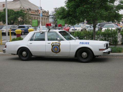 Silver Dodge Diplomat police sedan with gold star badge, side view