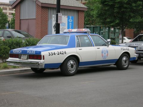 White and blue Norwich Police Chevrolet sedan rear three-quarter view