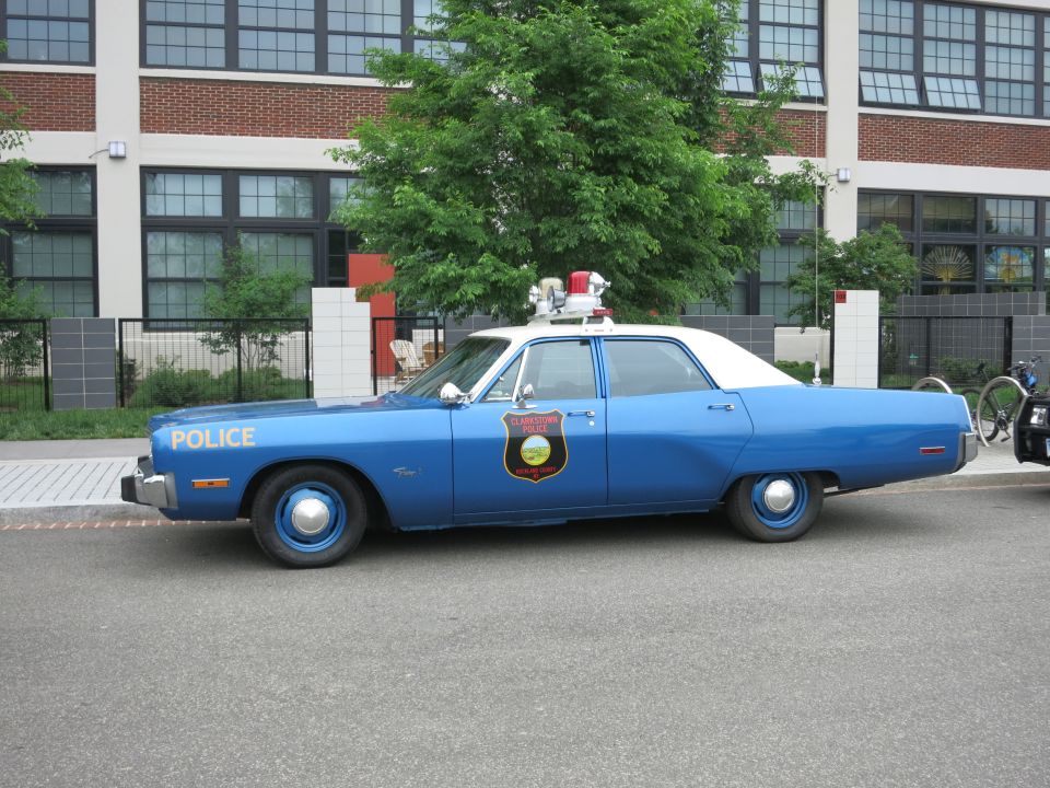 Blue and white 1970s police sedan with POLICE lettering, side view