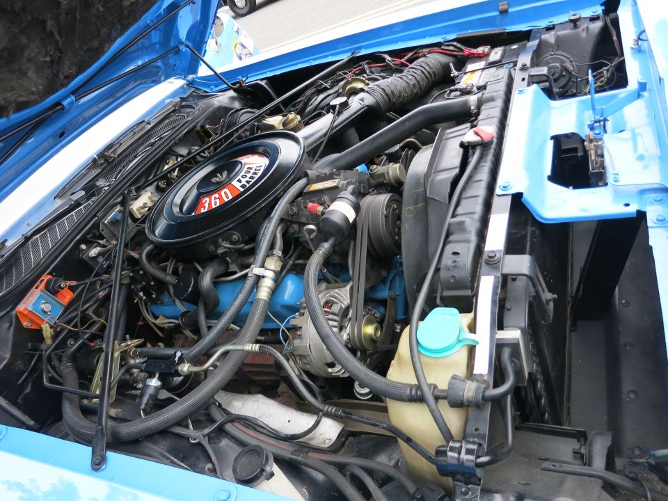 Close engine view showing a black 360 air cleaner, hoses, and coolant reservoir