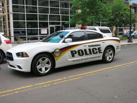 Front three-quarter view of a white Seminole Police Dodge Charger on a city street
