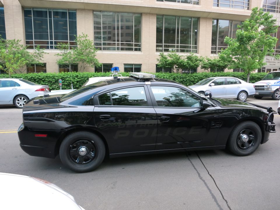 Side view of a blacked-out Dodge Charger police car with black wheels