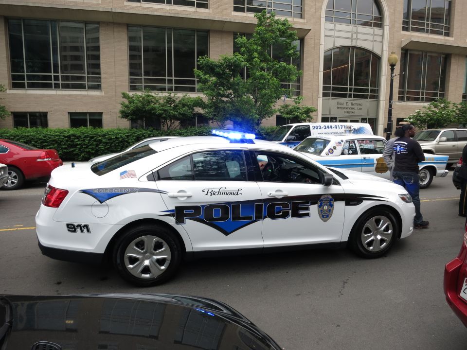 White Richmond Police Ford Taurus sedan with blue chevron markings on a street