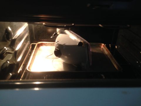 1992 Ford F-150 - A headlight assembly is being heated on a baking sheet inside an oven.