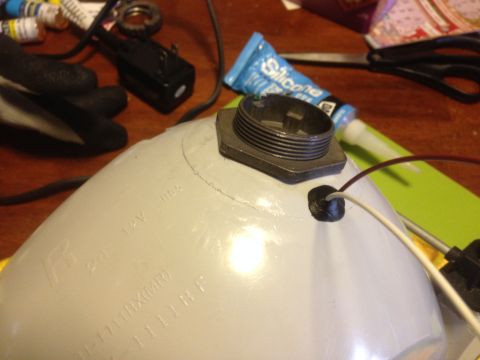 1992 Ford F-150 - Close-up of a headlight housing with electrical connections and a threaded adapter, surrounded by crafting supplies.