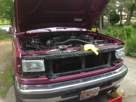 1992 Ford F-150 - Front view of a maroon 1992 Ford F-150 with the hood open and the grille removed, revealing the engine bay.