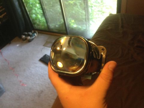 1992 Ford F-150 - A headlight projector is shown being held in a hand, with a watermark for Supermotors.net visible.