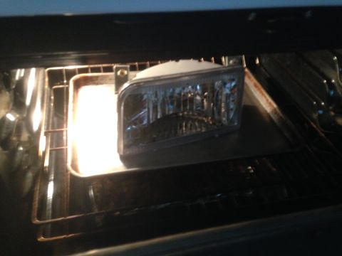 1992 Ford F-150 - Headlight assembly being heated in an oven, likely for modification or repair.