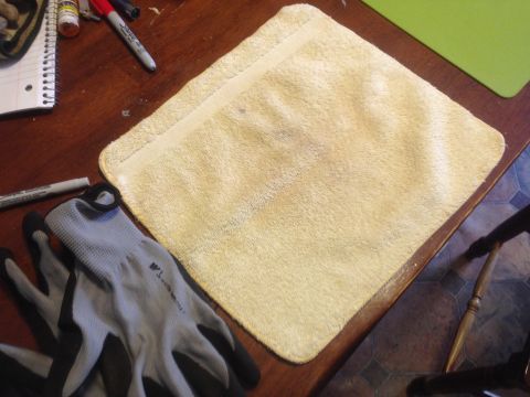 1992 Ford F-150 - A pair of work gloves, a yellow towel, and writing utensils are laid out on a wooden table surface.