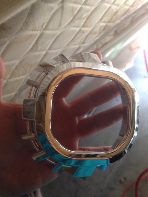 1992 Ford F-150 - A chrome trim piece, possibly for a headlight or grille, is held by a hand against a quilted background.