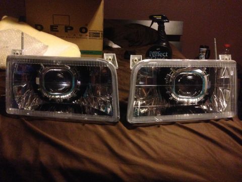 1992 Ford F-150 - A pair of aftermarket projector headlights are displayed on a brown surface, with a DEPO box in the background.
