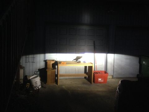 1992 Ford F-150 - Bright lights illuminate a workbench and a large garage door in a dimly lit garage.