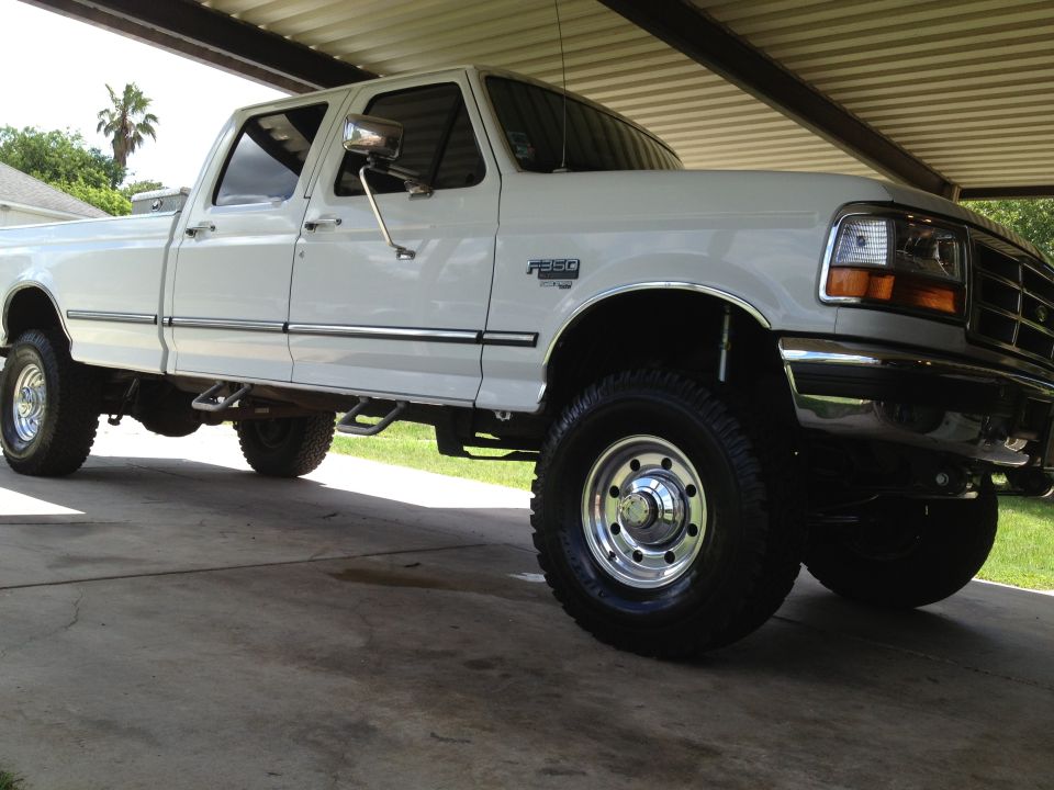 White 1997 Ford F-350 pickup truck, four-door cab, chrome trim, parked under a covered structure
