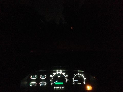1992 Ford F-150 - Illuminated dashboard gauges display PRND21 gear selection in a dark interior.