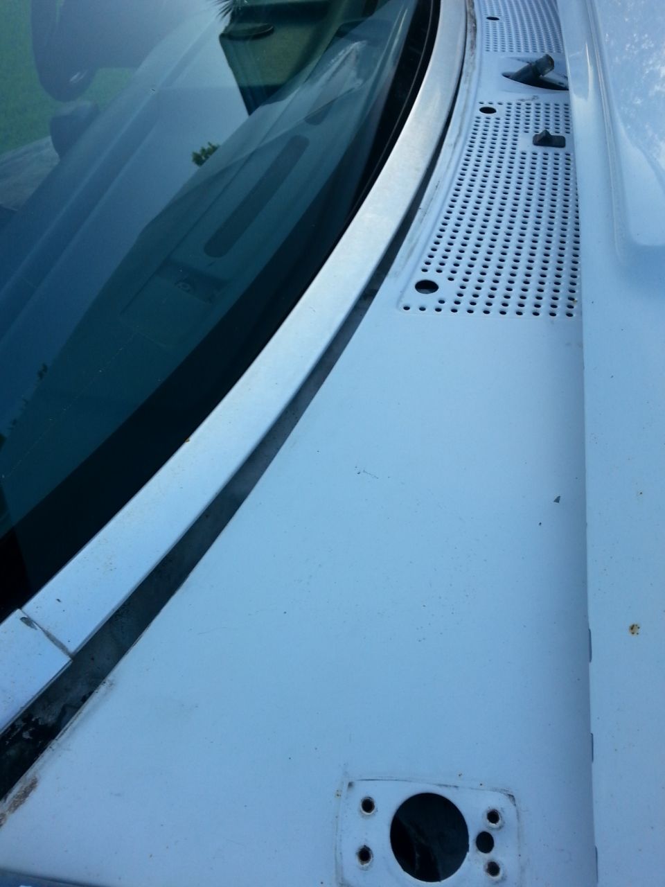 windshield cowl and wiper area of a white vehicle
