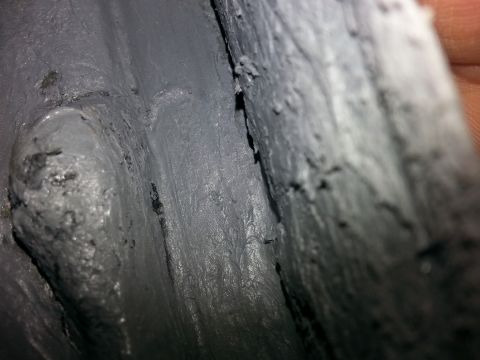 1992 Ford Bronco - Close-up view of grey sealant or undercoating, showing texture and application detail.
