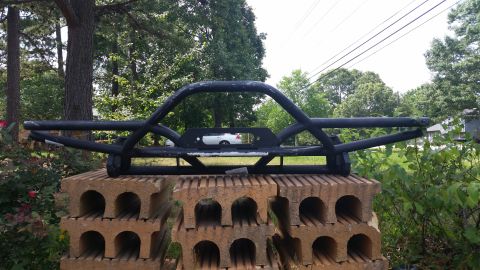 1988 Ford Bronco - Aftermarket front bumper with winch mount is displayed outdoors on concrete blocks.