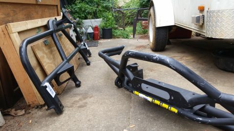 1988 Ford Bronco - Aftermarket front bumper guards are shown on a concrete surface next to a trailer.