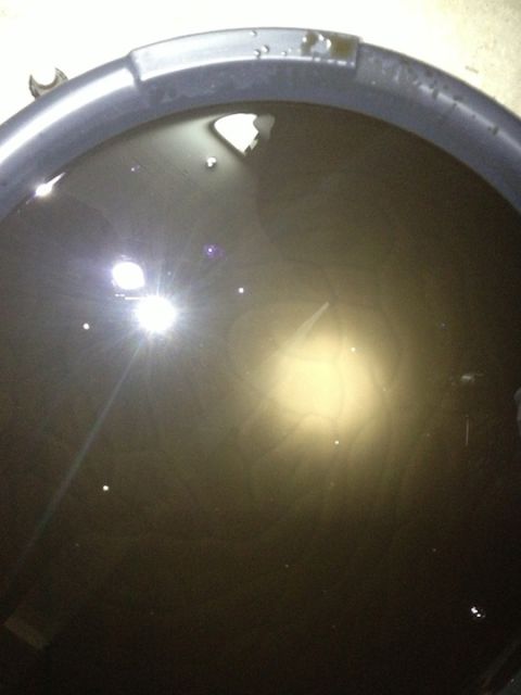 1961 International Scout 800 - A close-up view of dark, used oil collected in a black pan.