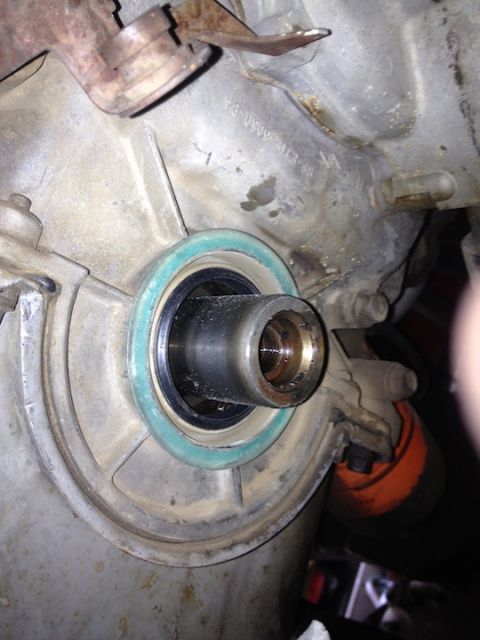 1961 International Scout 800 - Close-up view of a transmission seal, a green gasket and a metal shaft, likely during a motor install or repair.