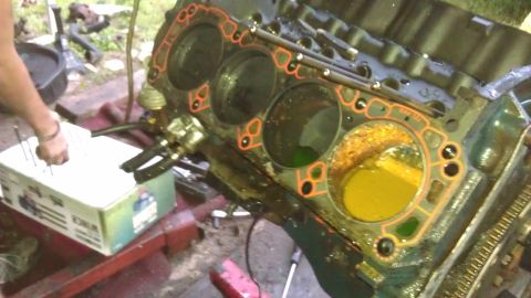 1994 Ford Bronco - Close-up of an engine block, showing cylinders and gasket work in progress.