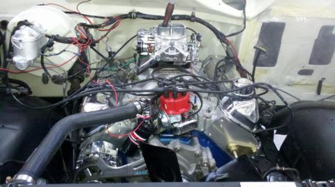 1982 Ford Bronco - The engine bay of a 1982 Ford Bronco shows a V8 engine with chrome accents and an aftermarket carburetor.