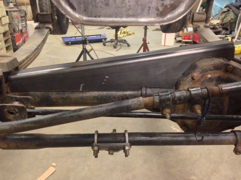 1993 Ford Bronco - Close-up view of the rear axle and suspension components of a vehicle undergoing work.