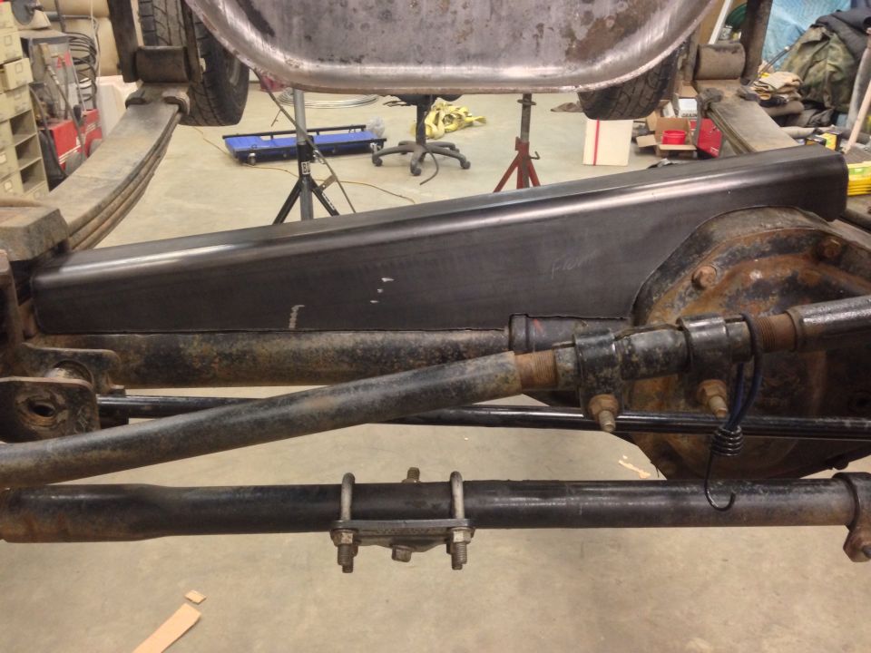 Underside of a vehicle showing leaf springs, differential, and frame components