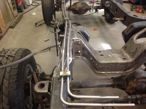 1993 Ford Bronco - Close-up view of the frame and suspension components of a vehicle, showing brake lines and part of a tire.