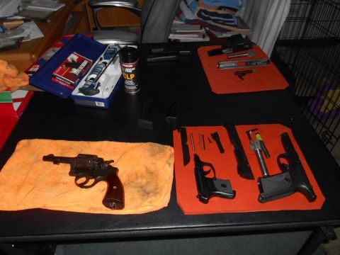 1994 Ford Bronco - Firearms laid out on a table for cleaning, alongside cleaning supplies.