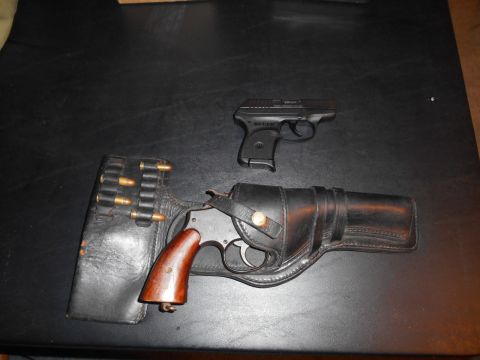 1994 Ford Bronco - A revolver with a leather holster and speed loader sits next to a compact semi-automatic pistol.