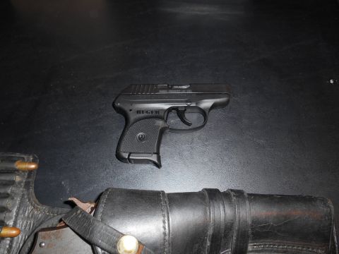 1994 Ford Bronco - A black Ruger pistol is shown with a leather holster and ammunition, suggesting a focus on firearm components.