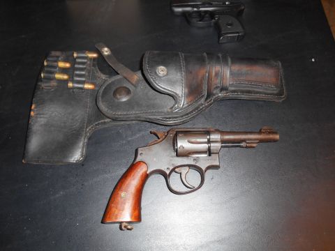 1994 Ford Bronco - A vintage revolver and a semi-automatic pistol are displayed with a holster and ammunition.