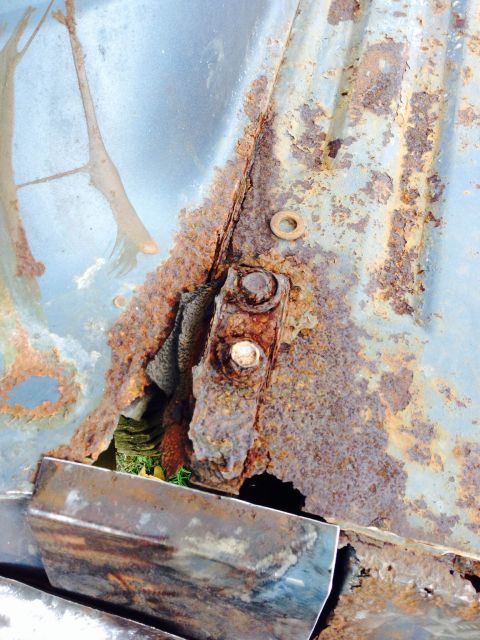 1979 Ford Bronco - This image shows significant rust and decay on a vehicle's metal components, obscuring any specific year identification.