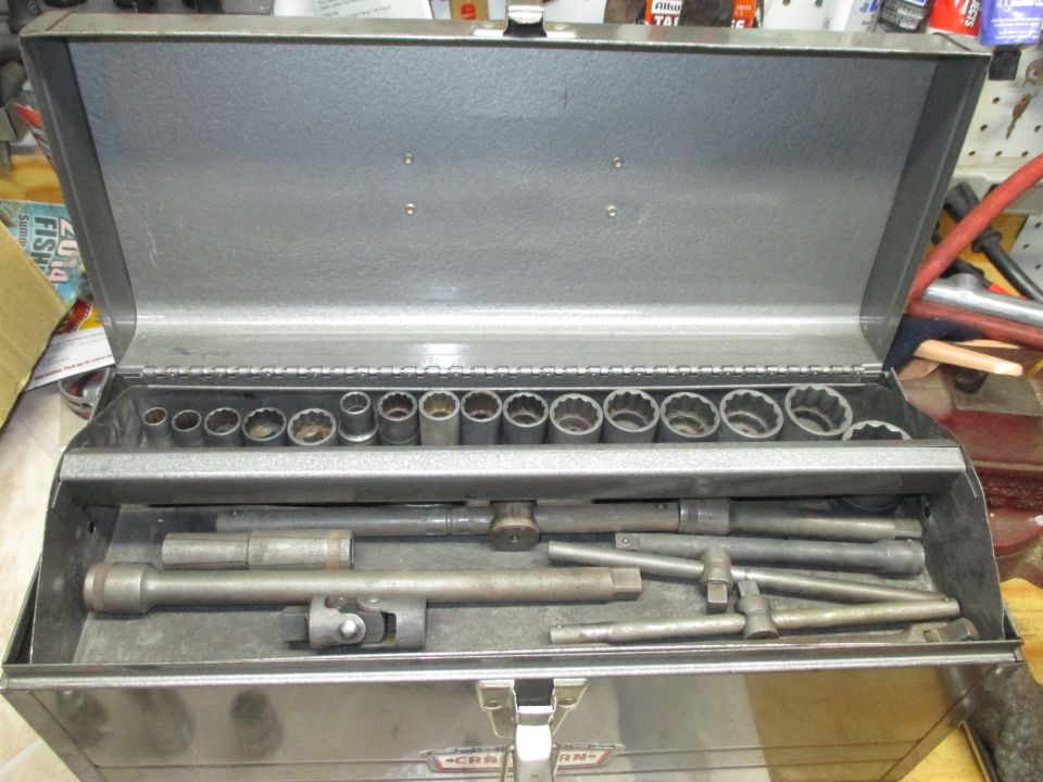 Metal tool chest open, showing sockets and extensions on two levels