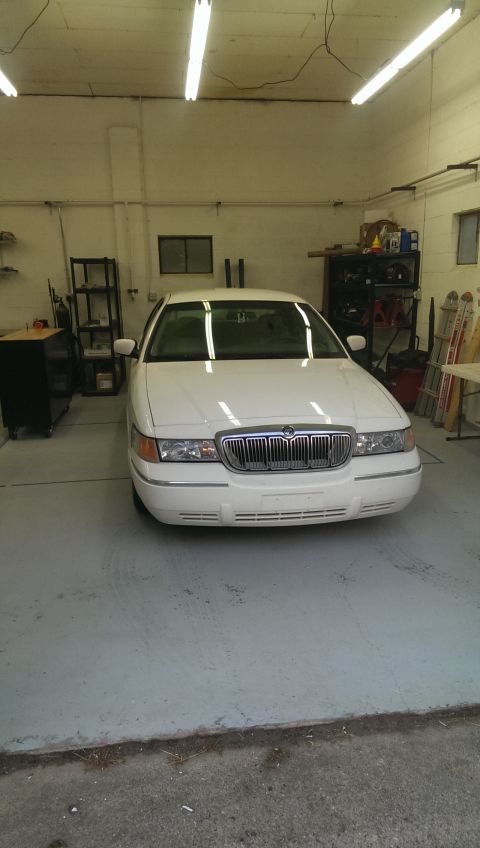 2000 Mercury Grand Marquis - This white 2000 Mercury Grand Marquis sedan is parked inside a garage with fluorescent lighting.