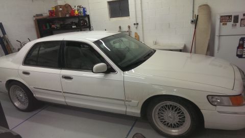 2000 Mercury Grand Marquis - A white 2000 Mercury Grand Marquis sedan is parked in a garage, viewed from the front passenger side.