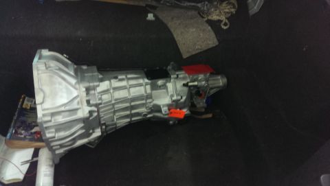2000 Mercury Grand Marquis - A silver transmission with red and orange accents is shown in a dark space, possibly a trunk or cargo area.