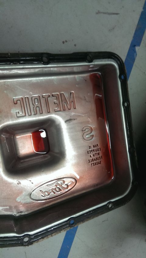 2000 Mercury Grand Marquis - A Ford transmission pan with some red fluid inside and "METRIC" stamped on the metal.