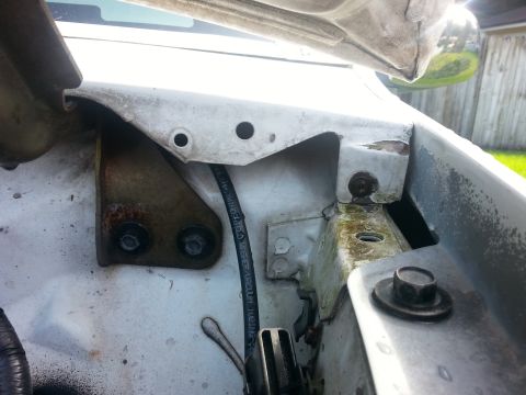 1992 Ford Bronco - Close-up view of the engine bay of a white vehicle, highlighting various mechanical components and signs of wear.