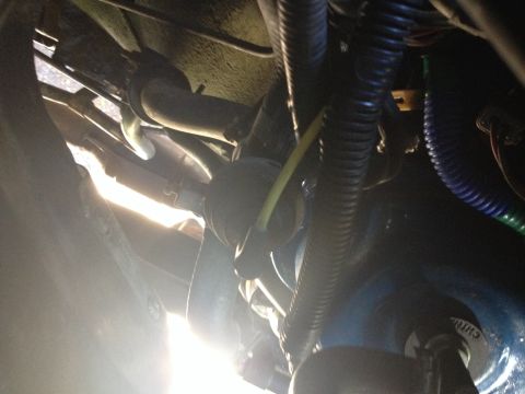 1988 Ford Bronco - A close-up shot reveals various hoses and wiring harnesses beneath a vehicle.