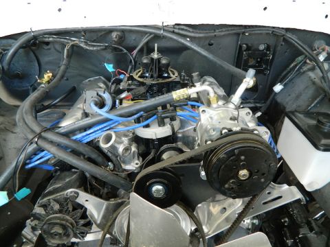 1979 Ford Bronco - Close-up view of an engine bay, highlighting the air conditioning compressor and associated plumbing.