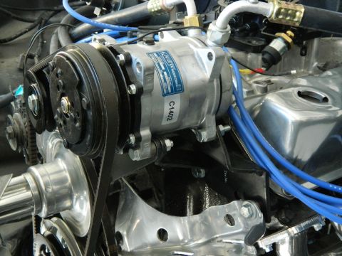 1979 Ford Bronco - Close-up view of an engine bay, focusing on the air conditioning compressor and associated components.