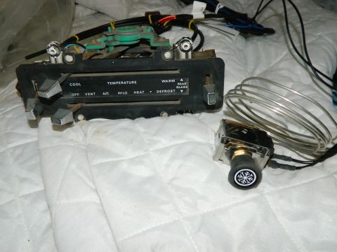 1979 Ford Bronco - A car's climate control panel and a separate temperature knob are shown against a white quilted background.