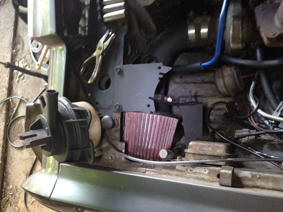 Bracket installed. You can see the trimming I had to do so the bracket would clear all the reinforcing ribs and such under the plastic lip. Not sure how Chrysler secured this originally. Mine lifts straight up after you loosen the two bolts on top and the one underneath.